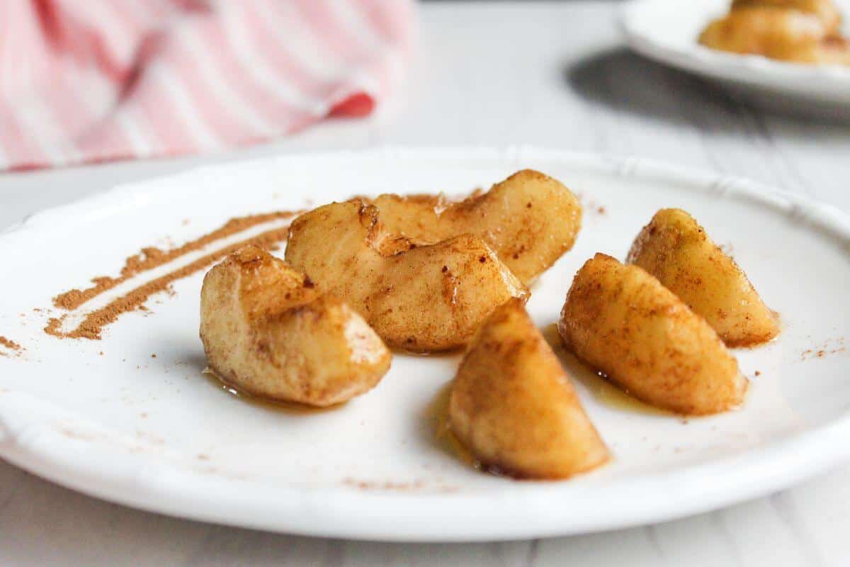 Air fried apple slices on a white plate.