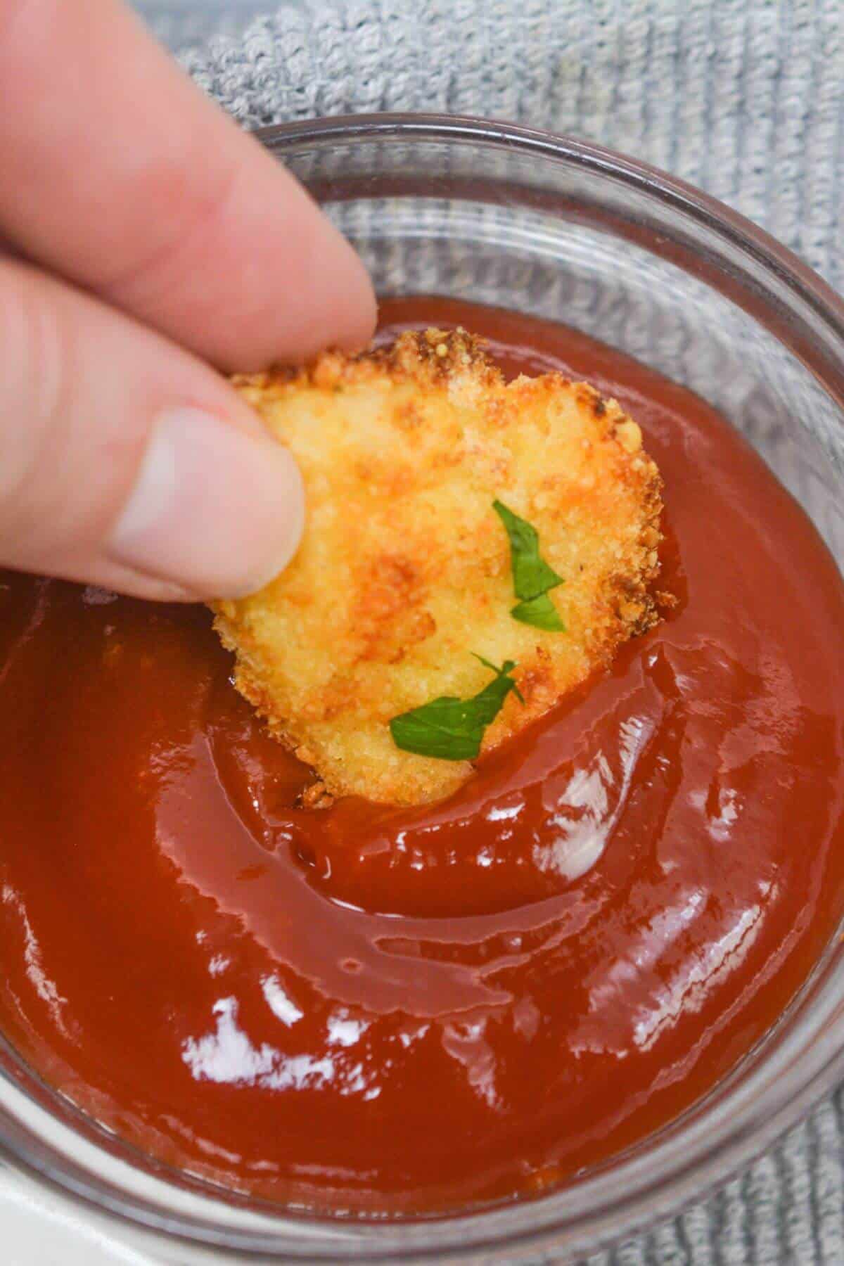 Dipping chicken nugget into barbecue sauce.
