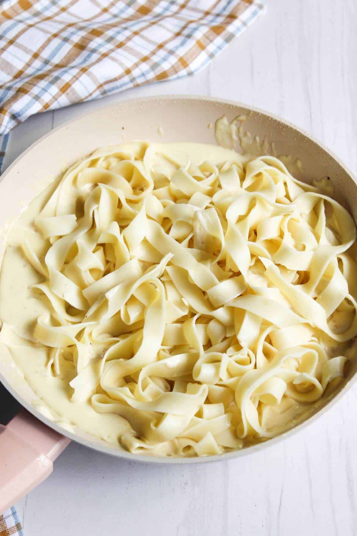 Pasta added to alfredo sauce.