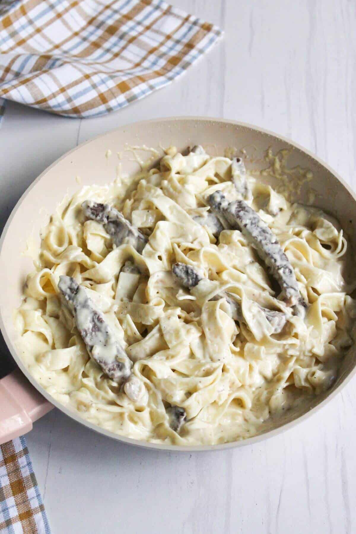 Alfredo steak pasta in skillet.