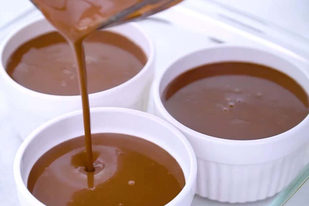 Pouring chocolate mixture into ramekins.