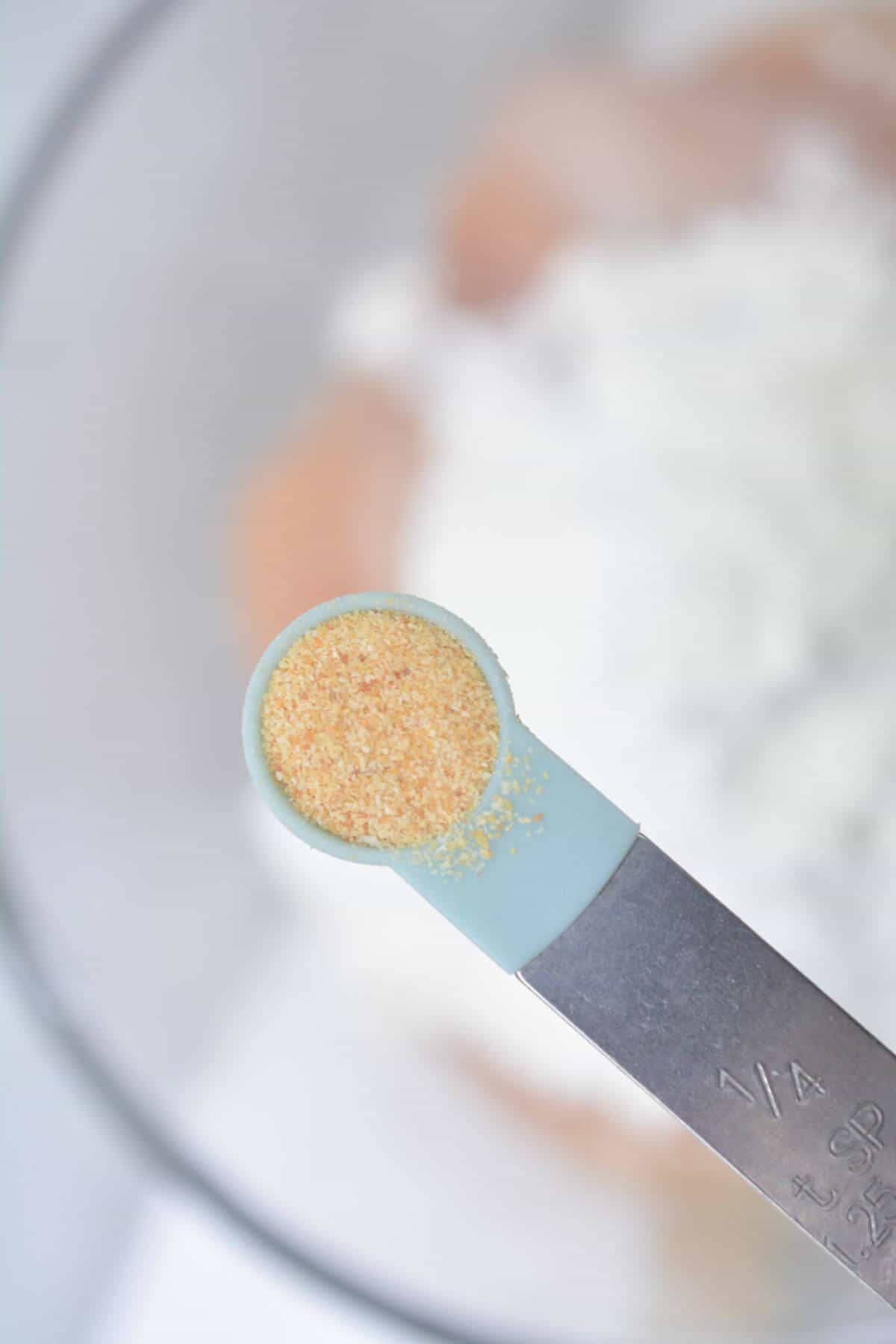 Adding garlic powder to bowl.