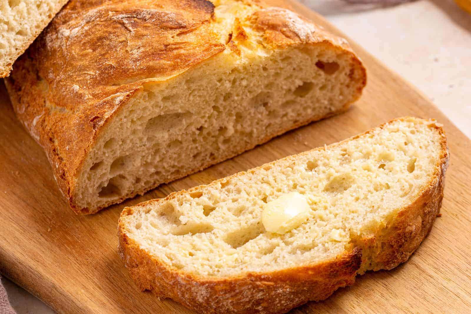 Italian artisan bread sliced on cutting board.