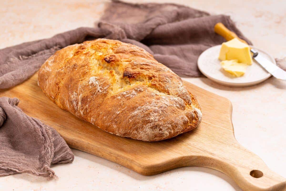 No knead Italian artisan bread loaf on cutting board.