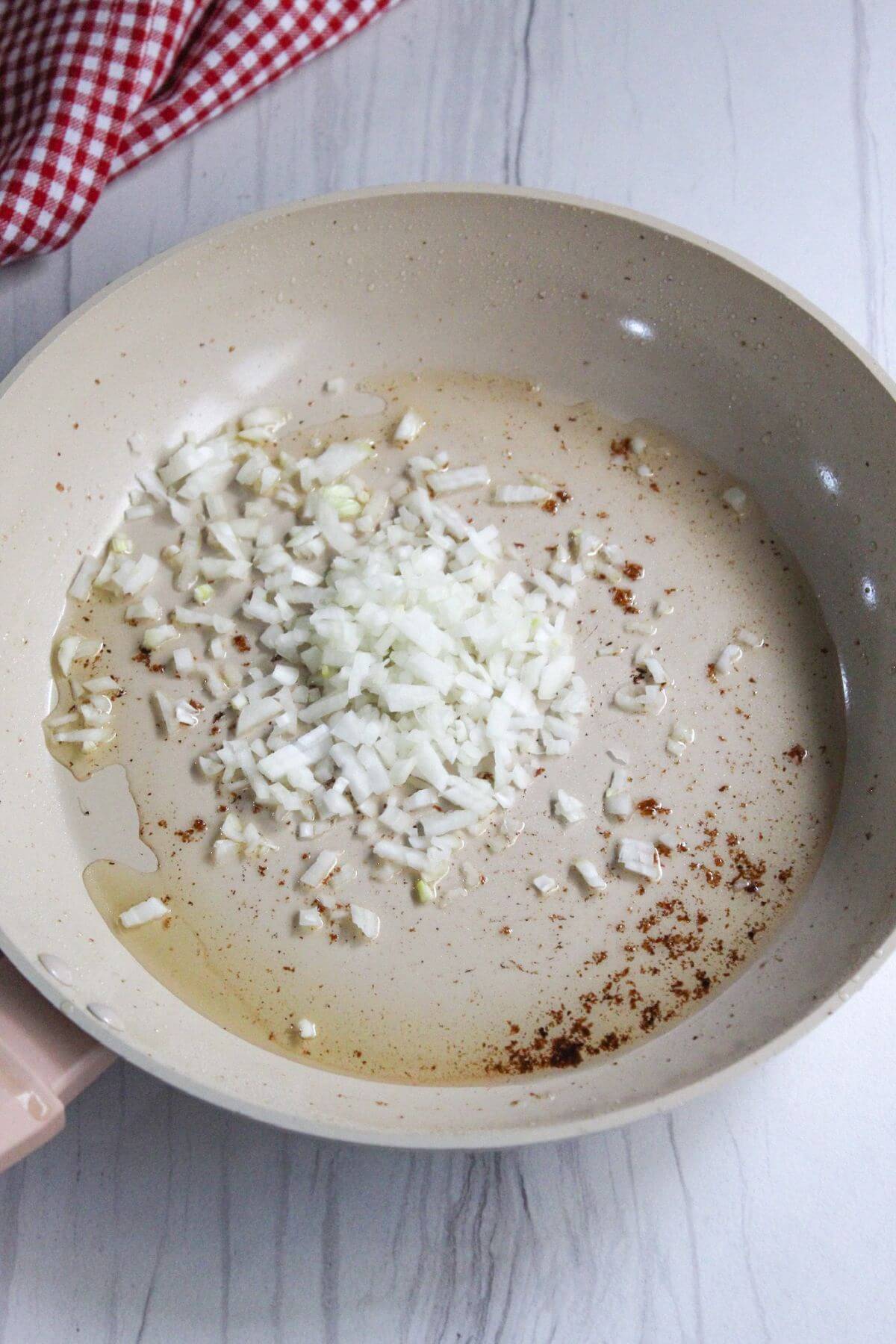 Chopped onions added to bacon fat in skillet.