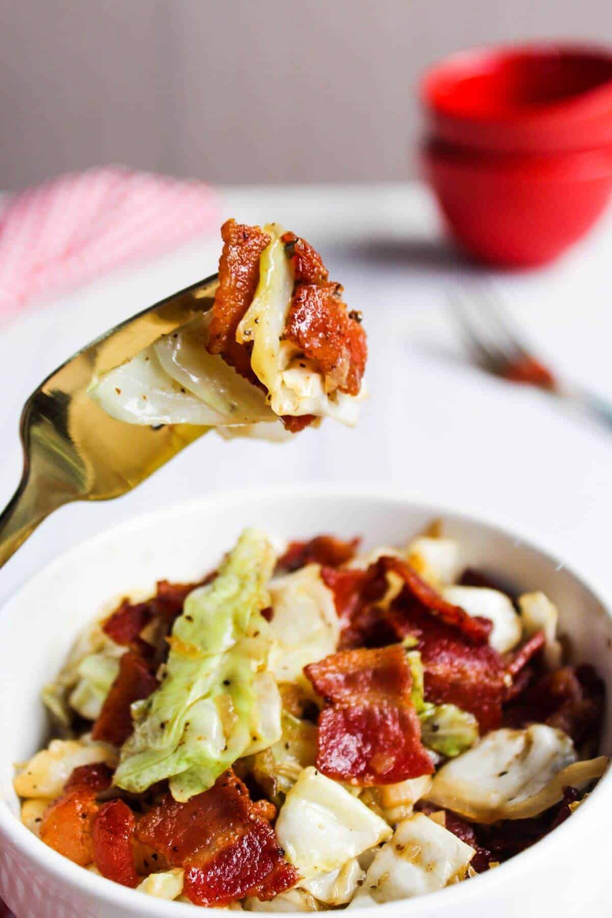 Southern fried cabbage in bowl and on fork.