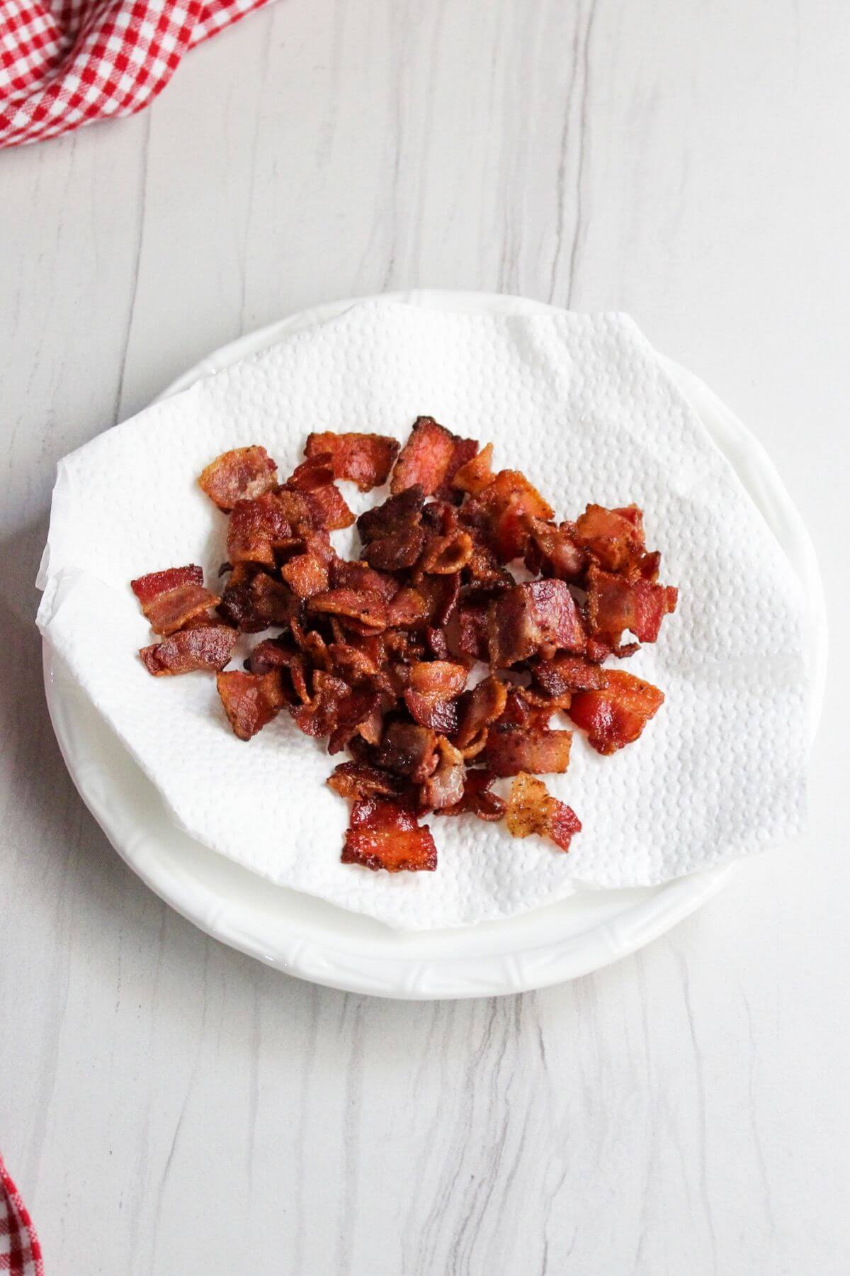 Cooked bacon pieces on paper towels.