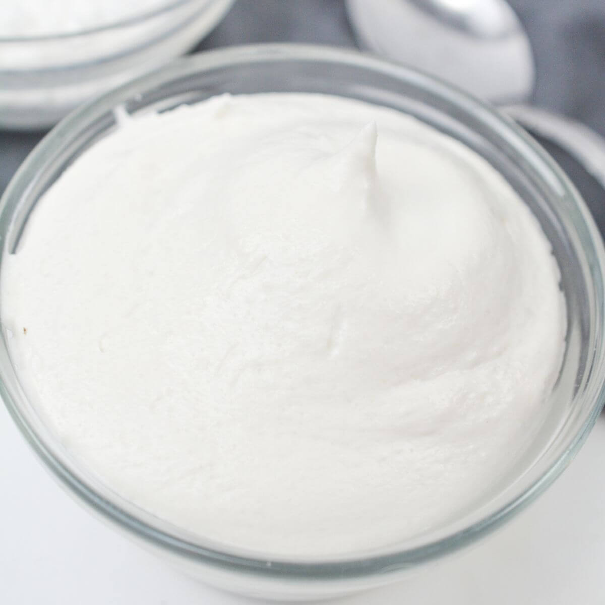 Vegan whipped cream in small glass bowl.