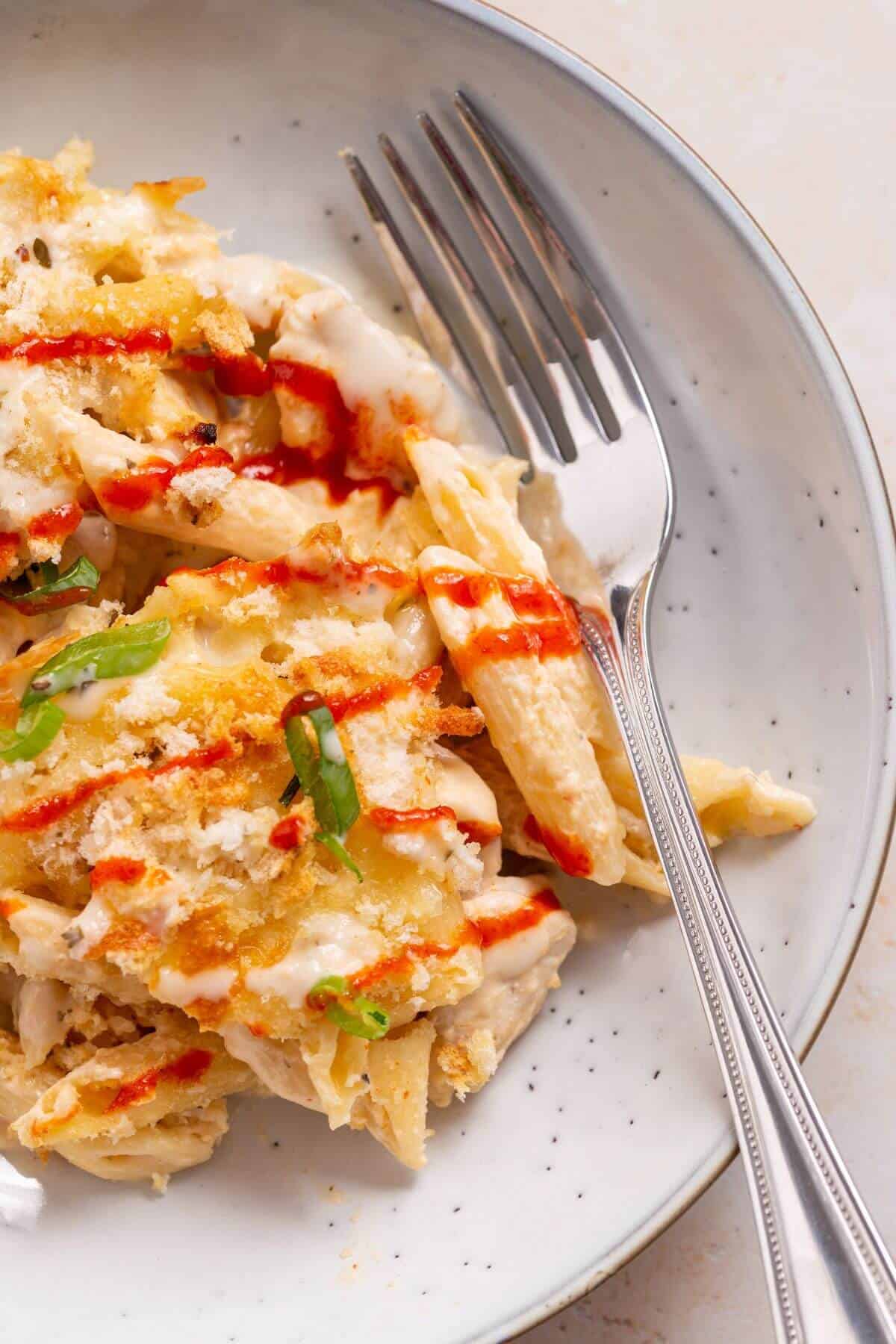 Buffalo chicken pasta bake on serving plate with fork.