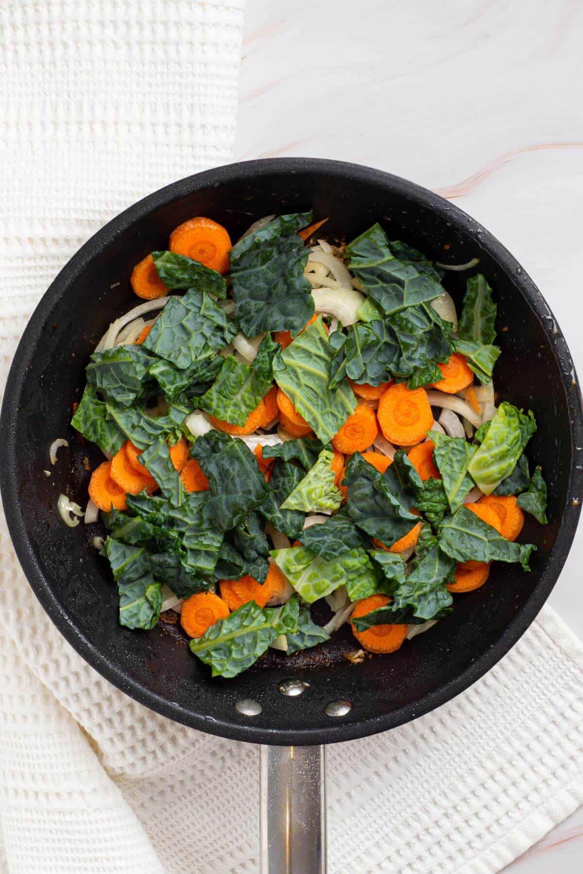 Carrots and cabbage added to skillet.