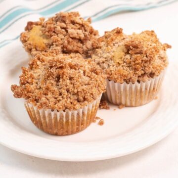 Cinnamon coffee cake muffins on a white plate.