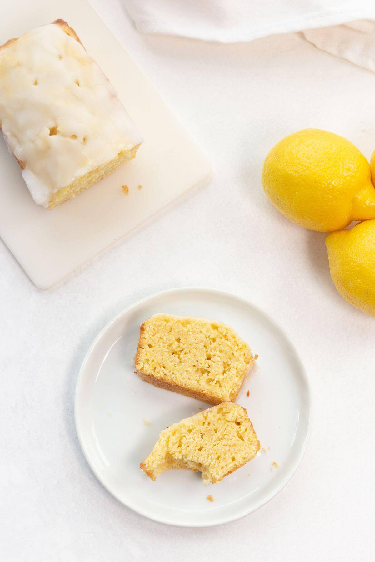 Sliced pieces of lemon loaf on plate with one bitten.