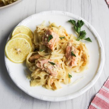 Plate with salmon alfredo serving.
