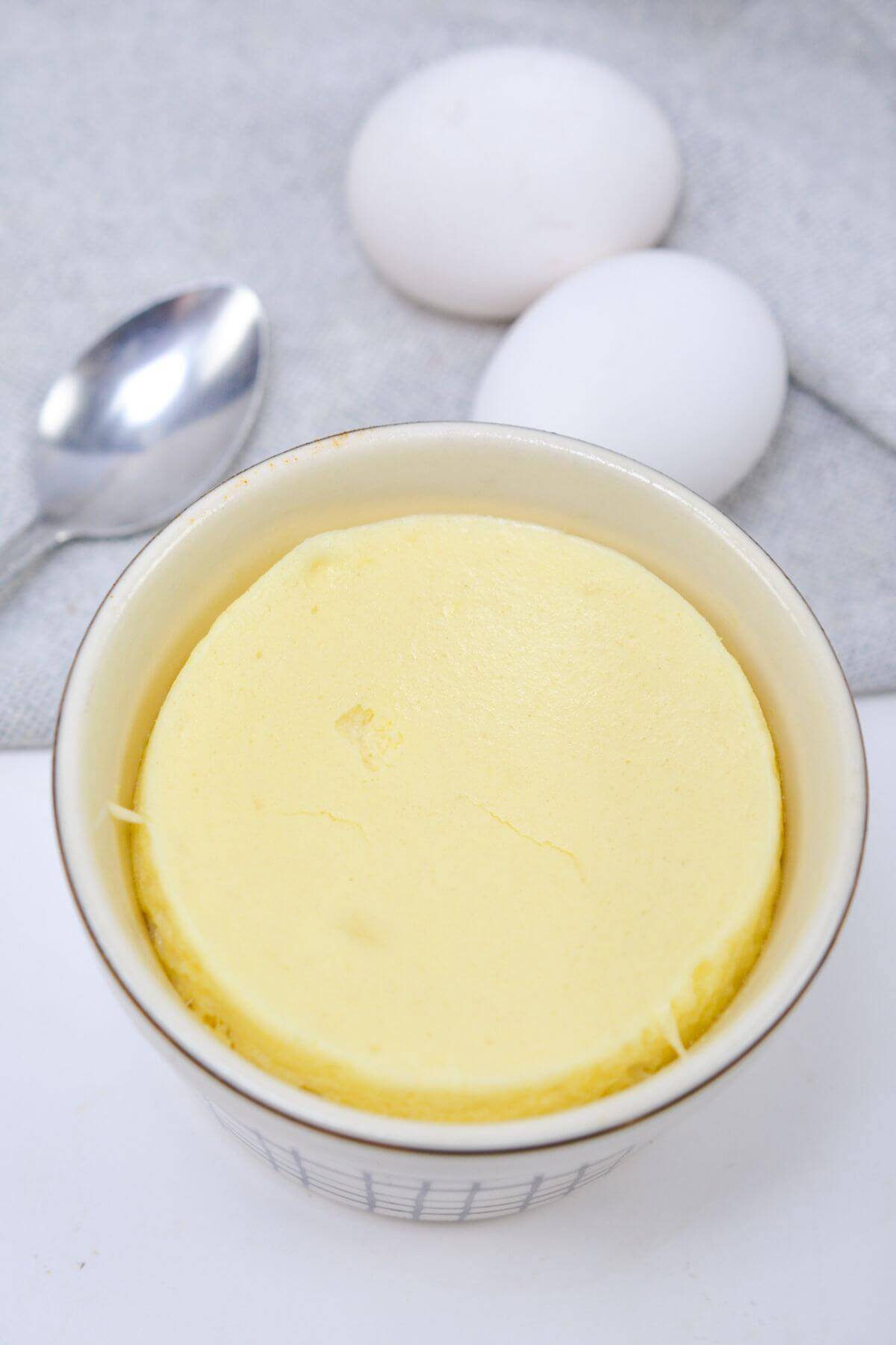 Baked souffle cheesecake with spoon and eggs.