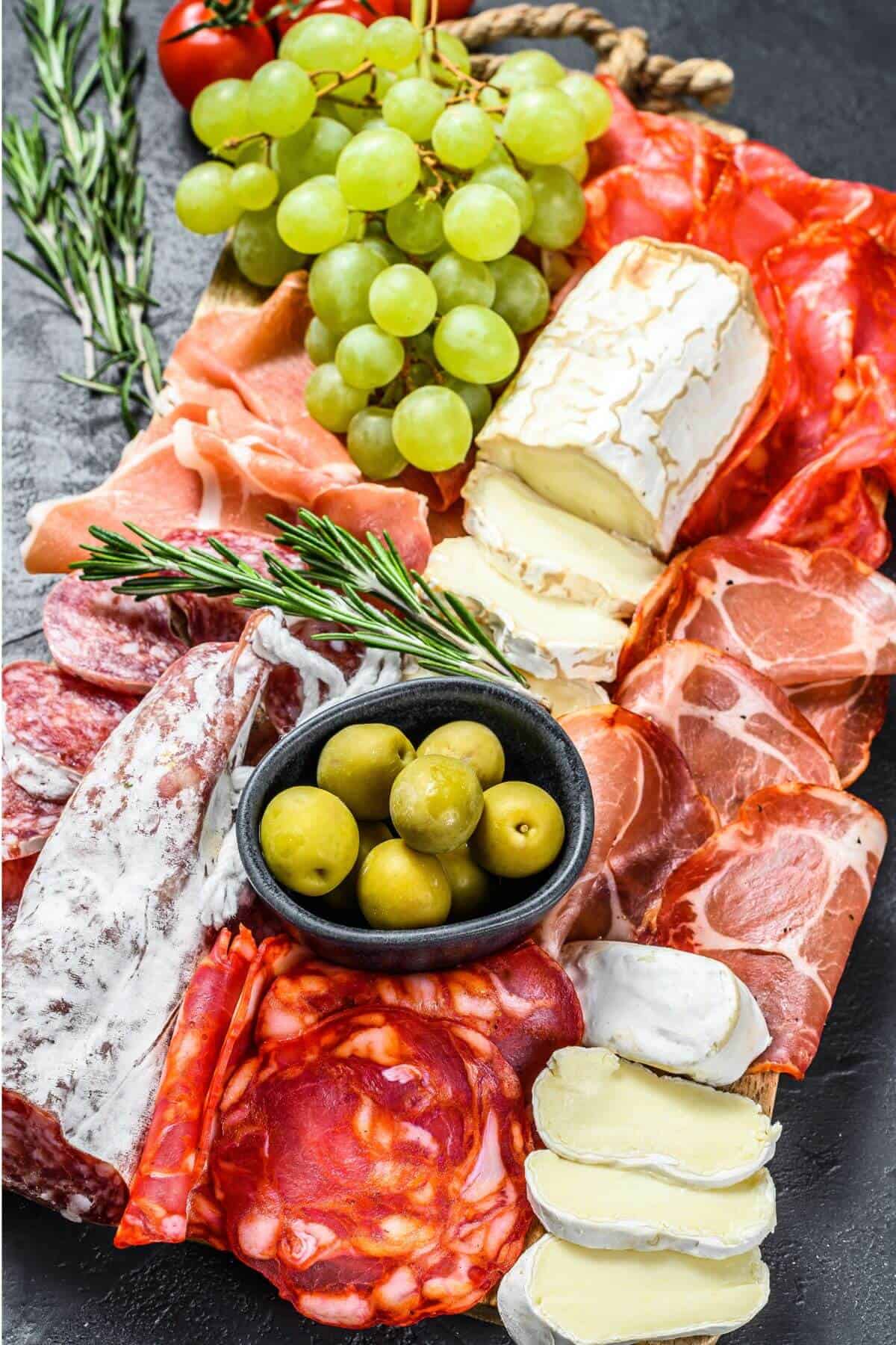 Charcuterie board with meat, cheese, and fruit.