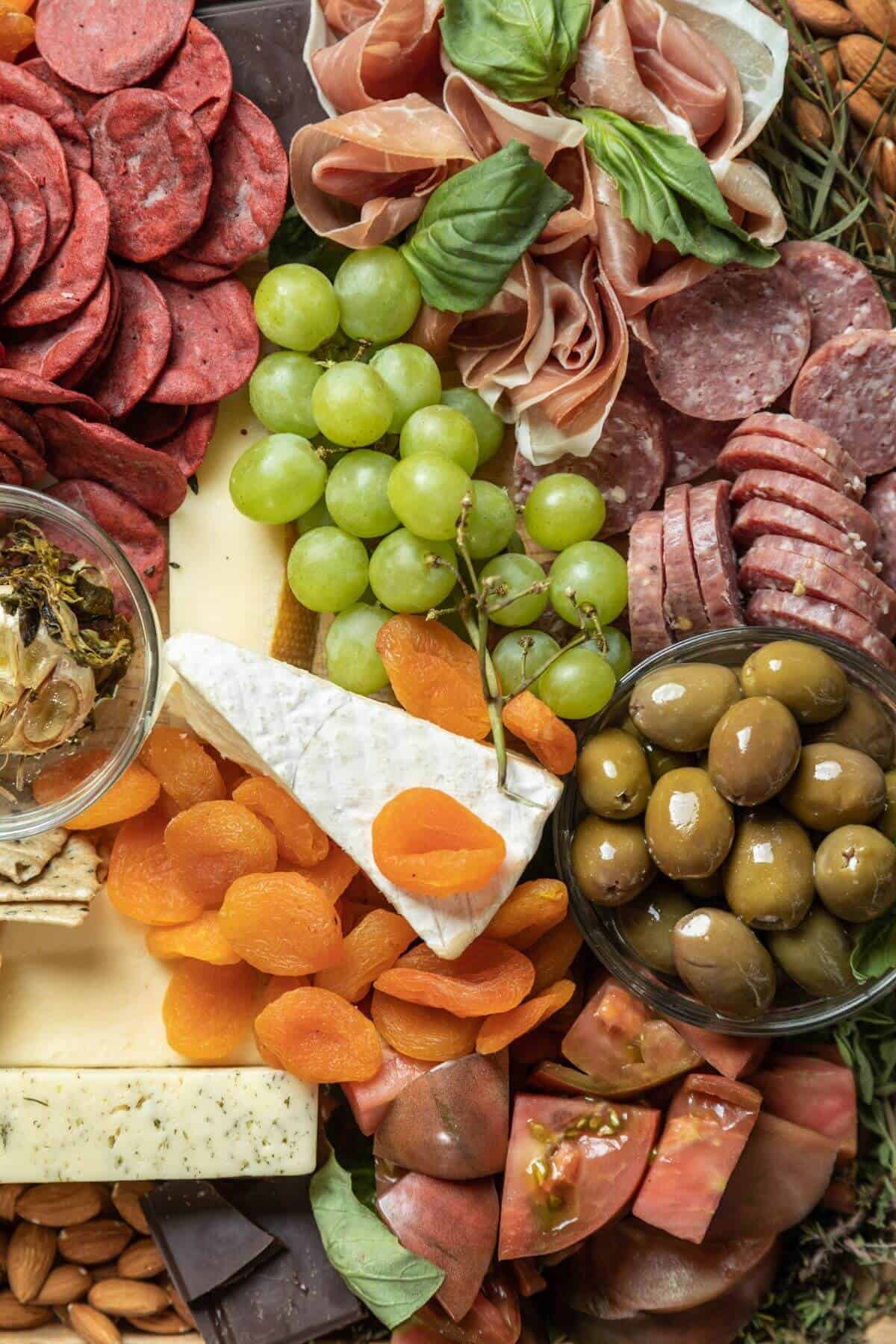 Assortment of meat, cheese, fruit, spreads.