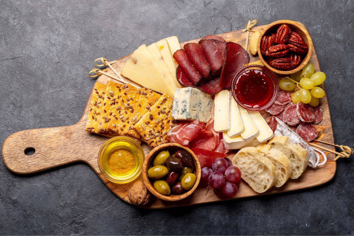 Charcuterie board with meat, cheese, crackers, and fruit.