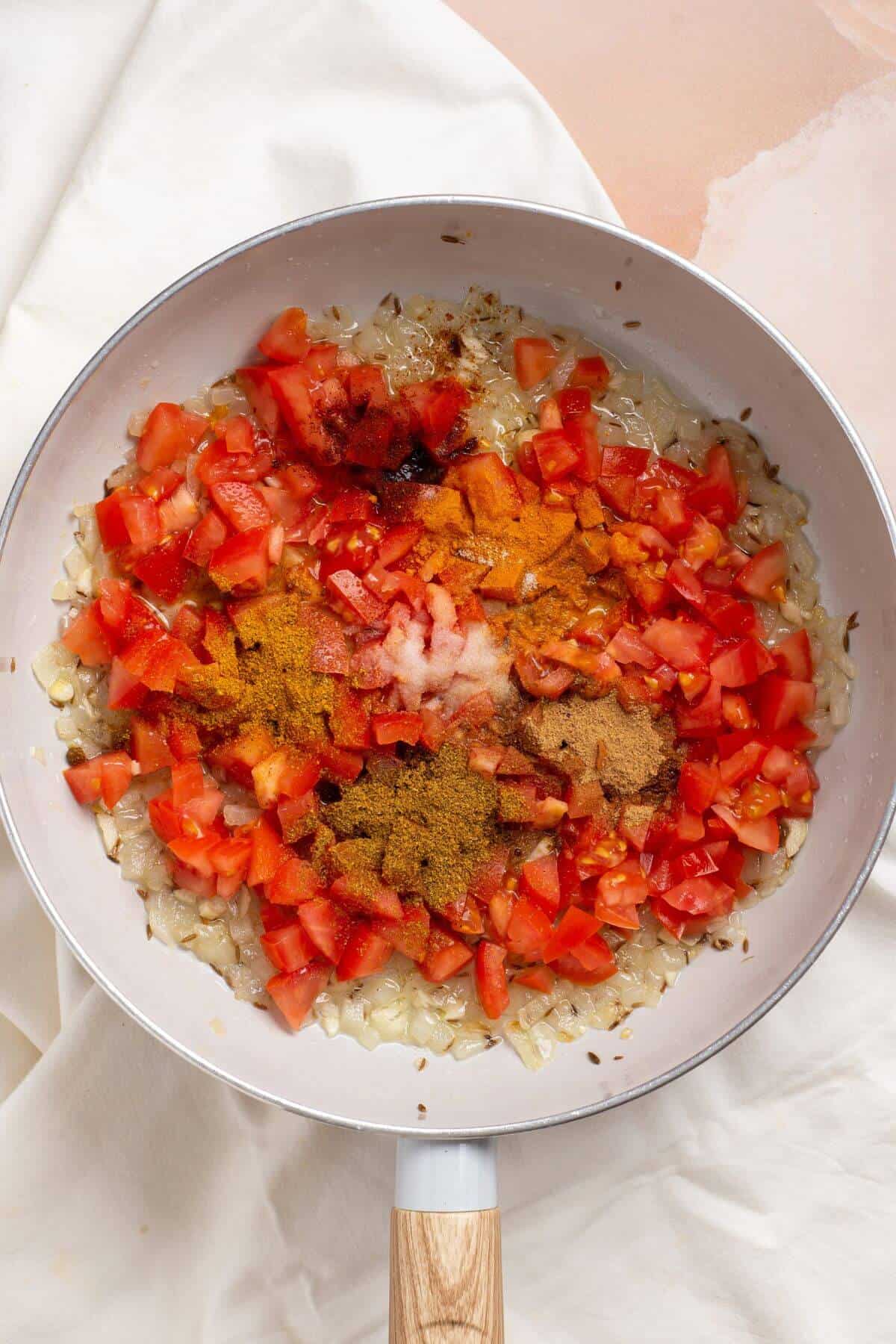 Tomatoes and spices added to skillet.