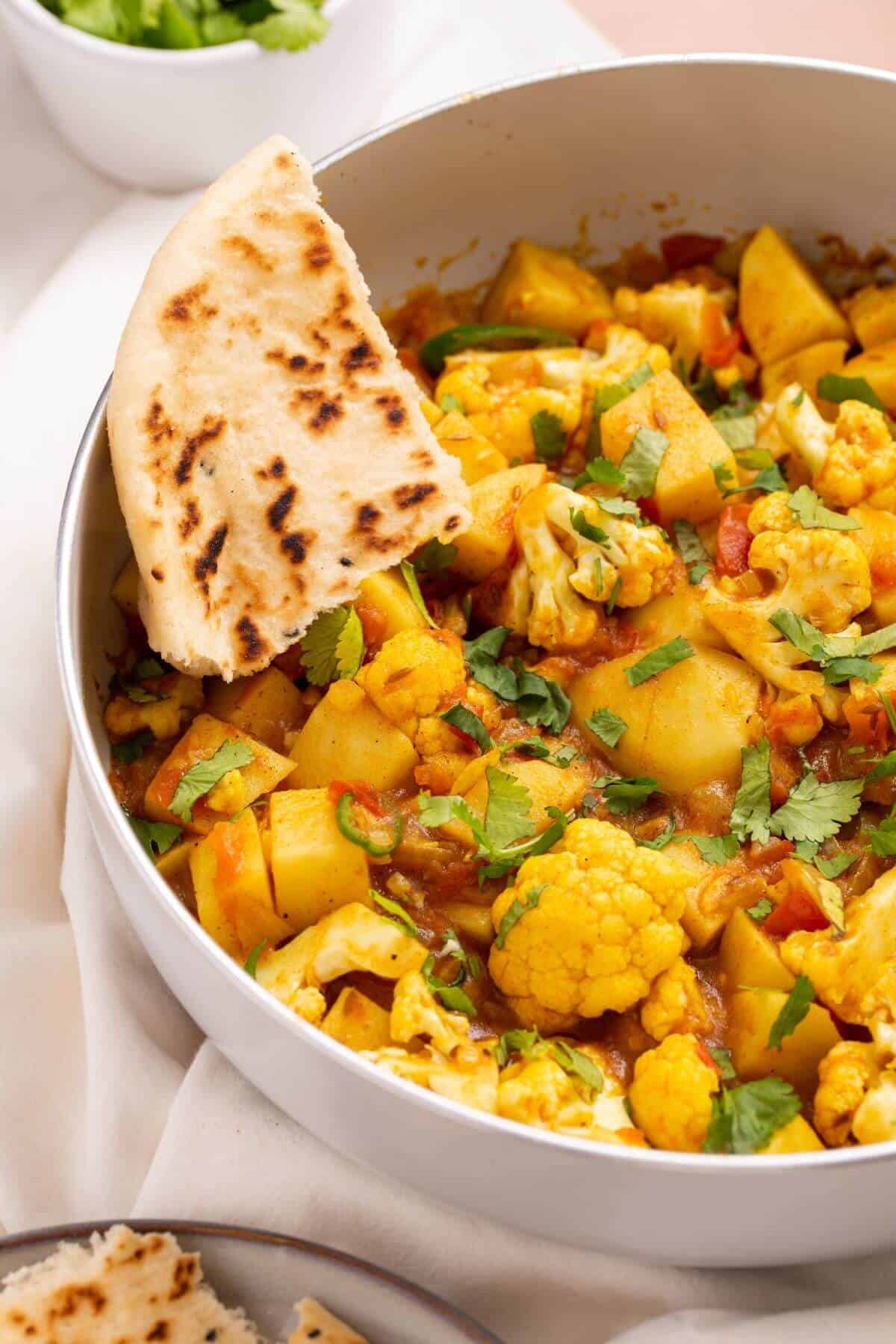 Closeup of aloo gobi masala with naan bread.