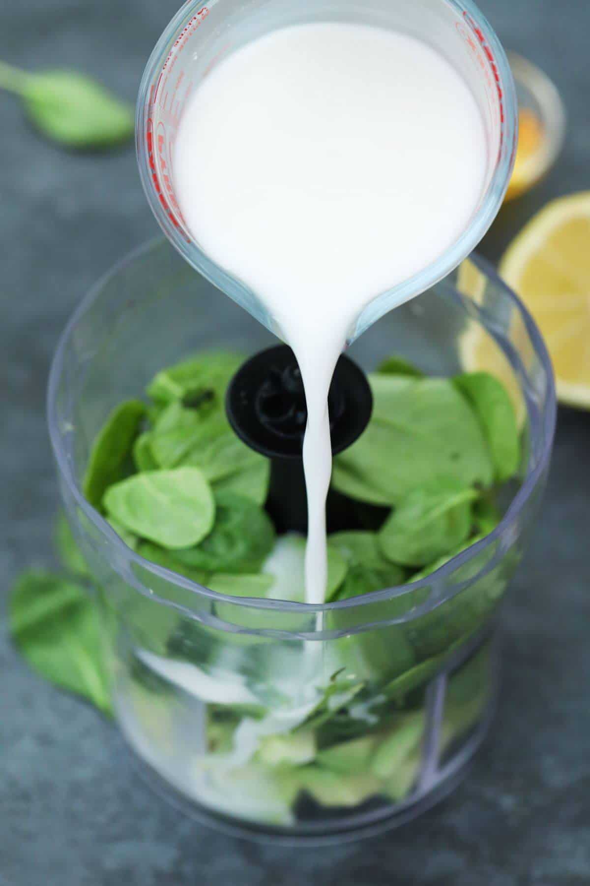 Pouring almond milk into blender.