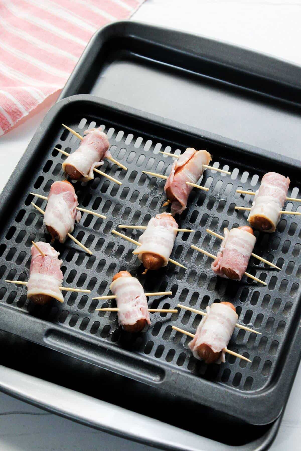 Bacon wrapped smokies on air fryer tray.
