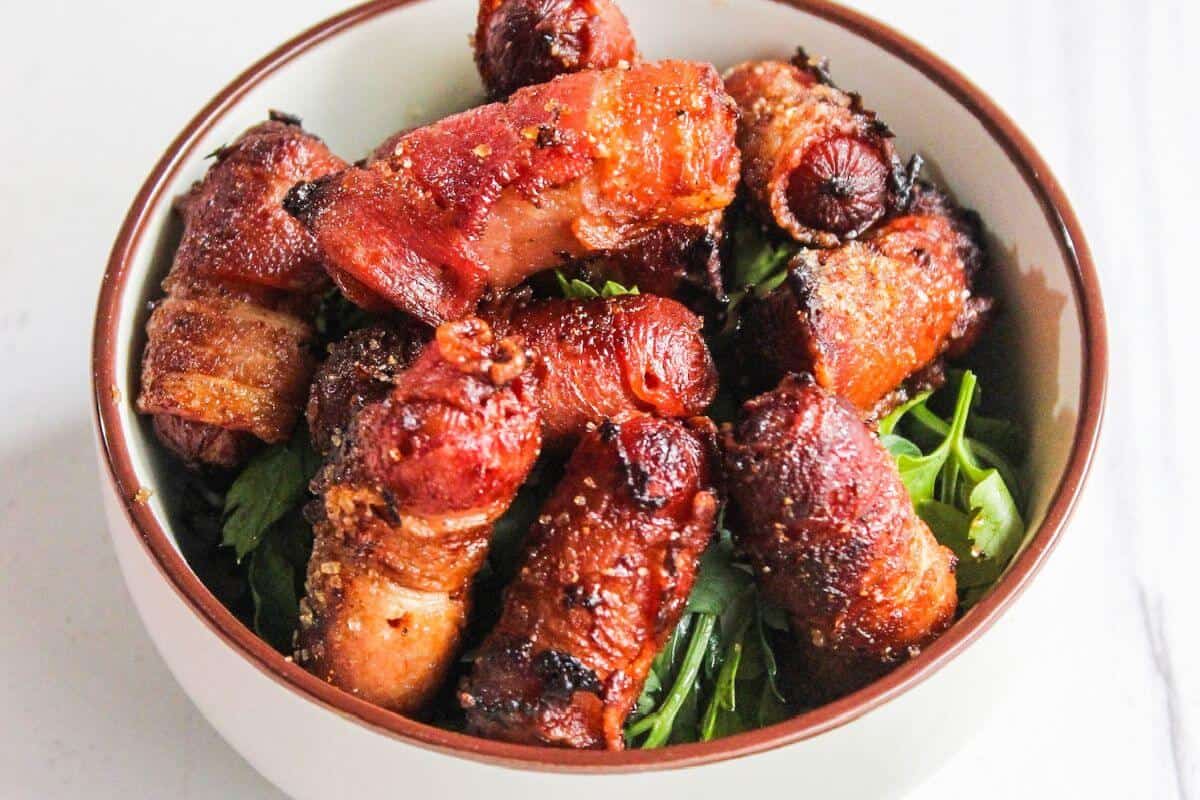 Bacon wrapped little smokies in a bowl.