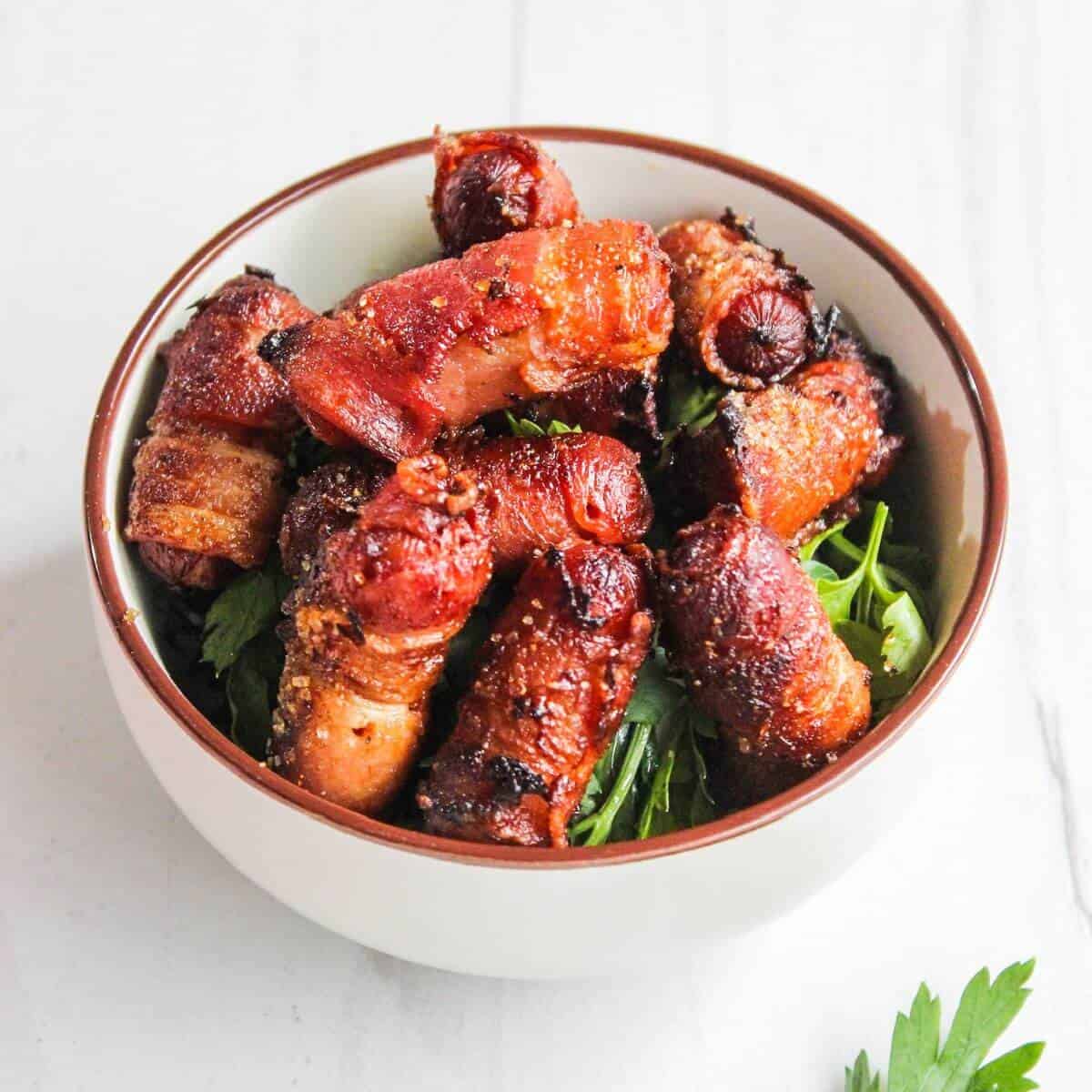 Bacon wrapped little smokies in a bowl.