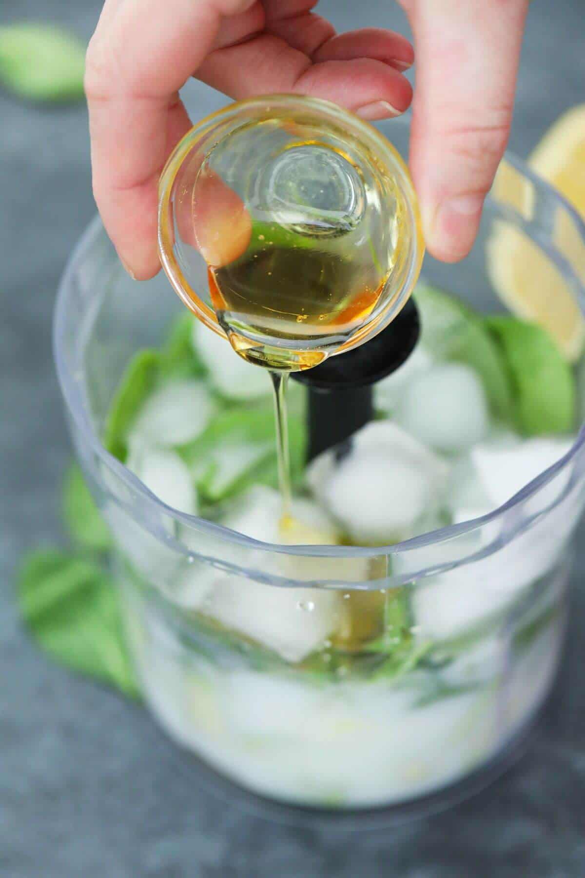 Pouring honey into blender container.