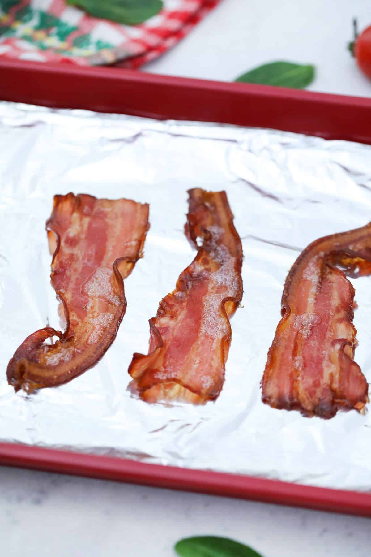 Cooked bacon in lined sheet pan.