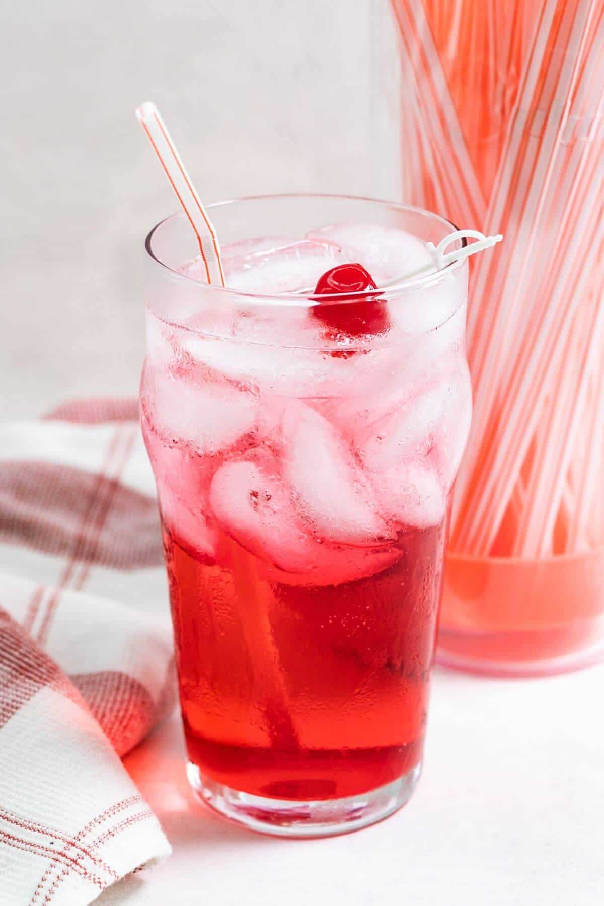 Shirley temple cocktail with straw.