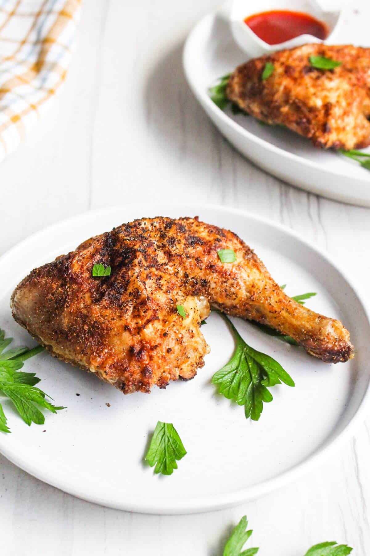 Air fried chicken leg on plate with parsley.