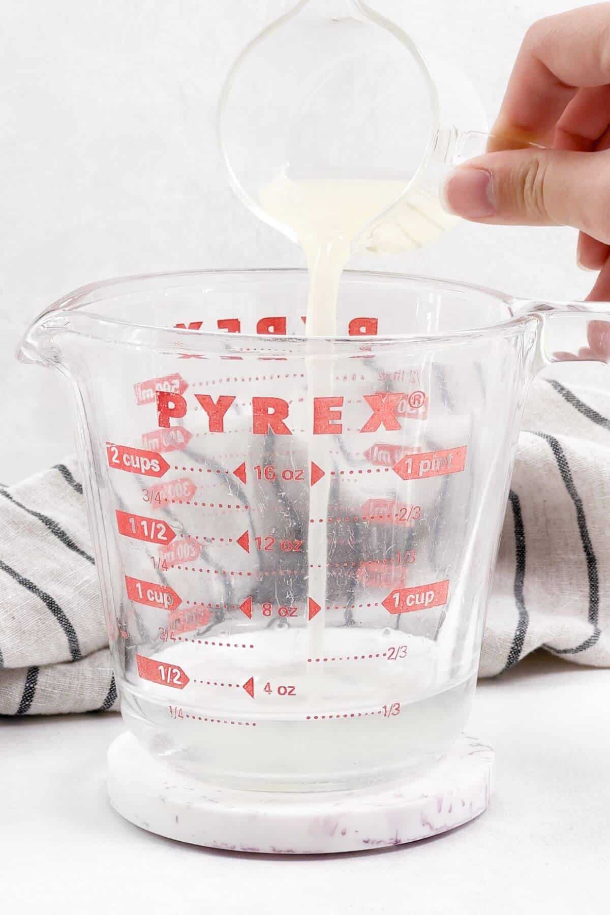 Pouring lemon juice into Pyrex measuring cup.