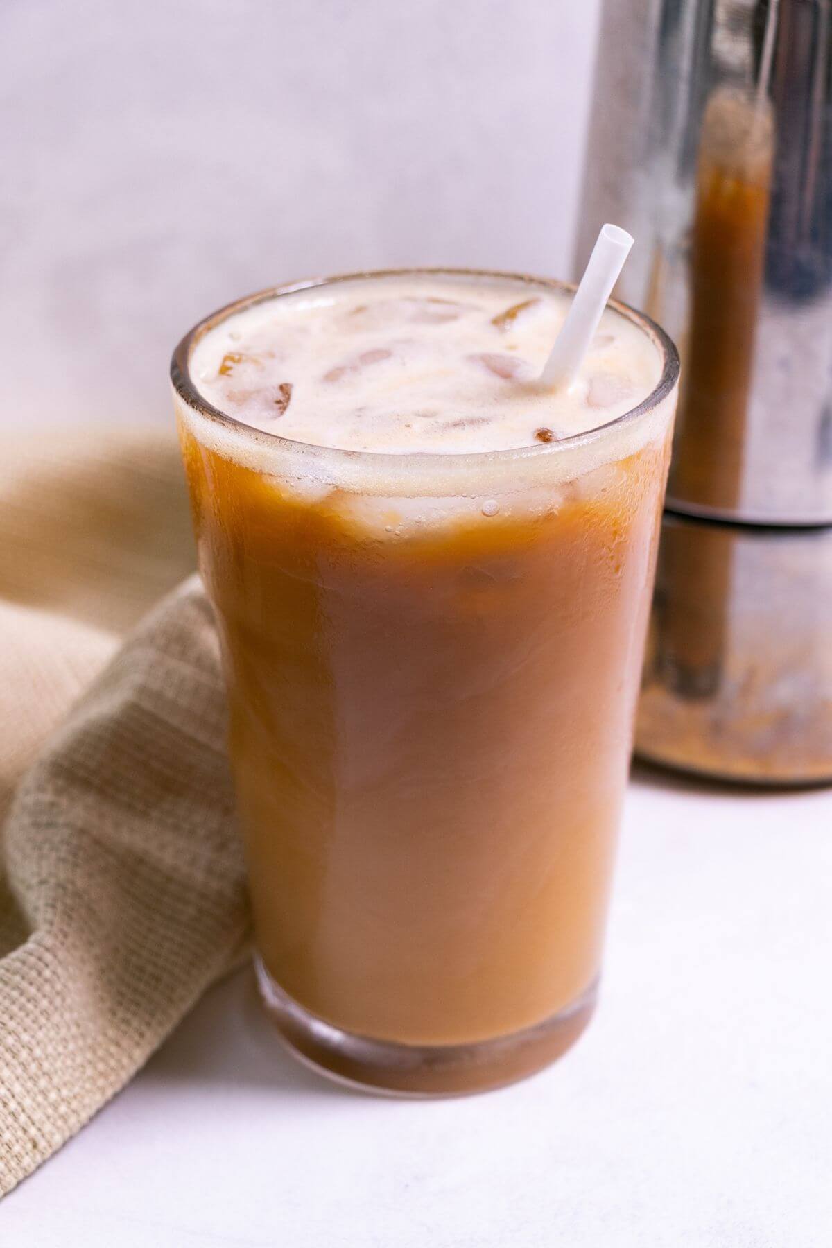 Iced Americano in tall glass with cream.