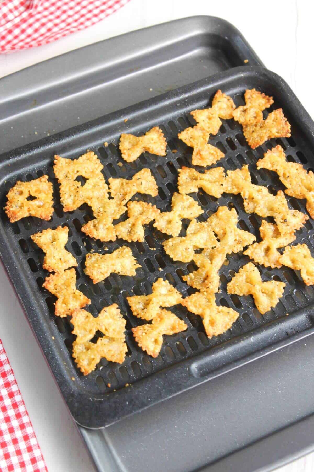 Air fried pasta on air fryer basket tray.