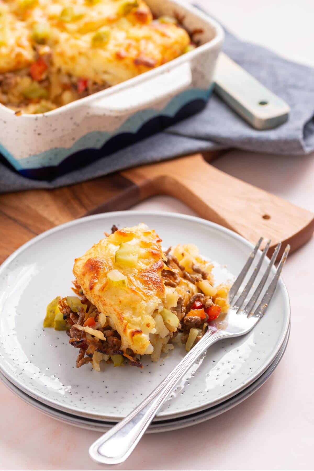 Sloppy joe casserole served on plate with pan in back.