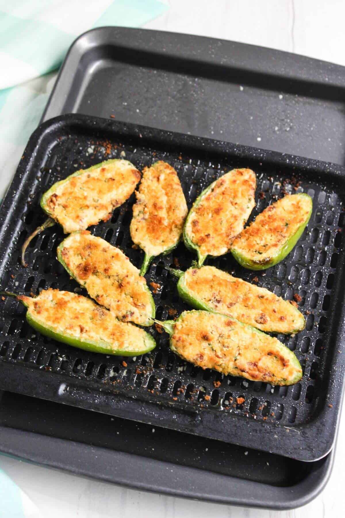 Air-fried jalapeño poppers on air fryer tray.