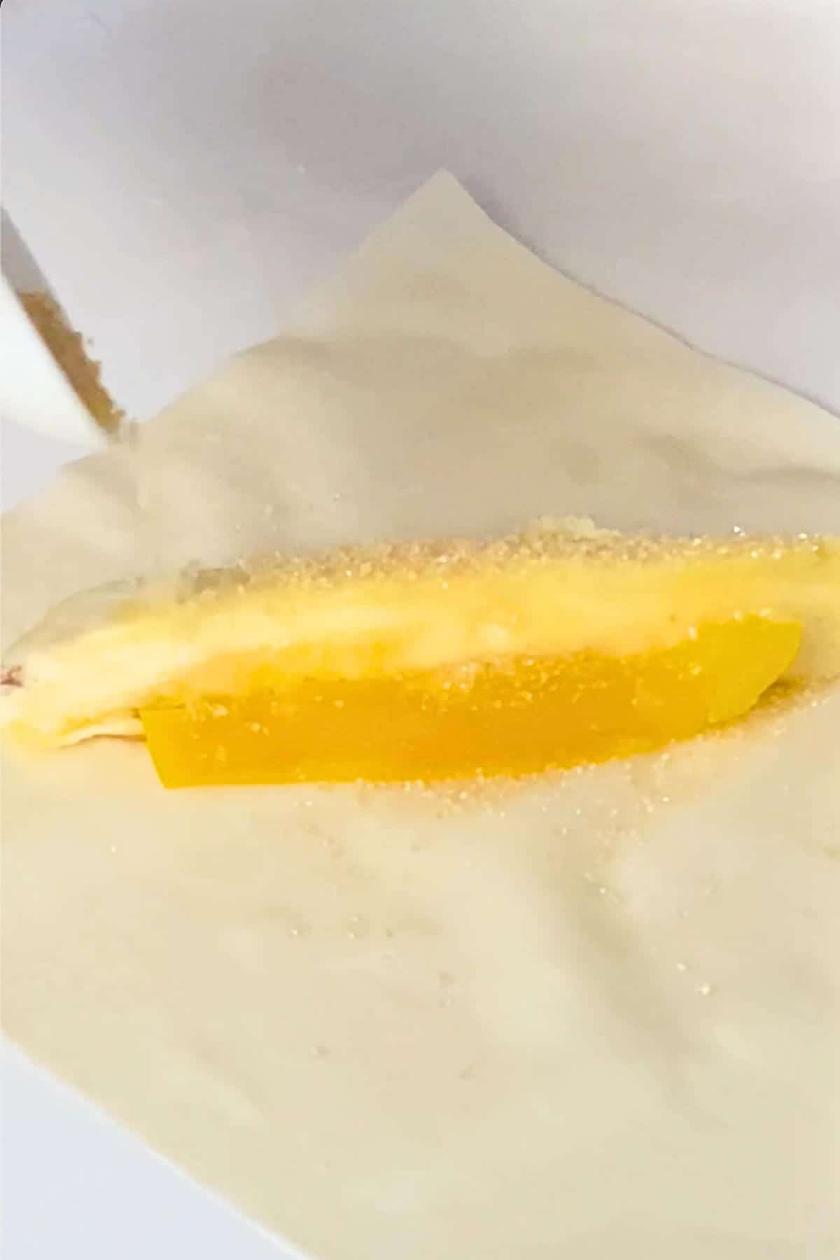 Banana and jackfruit slices being placed on a lumpia wrapper.