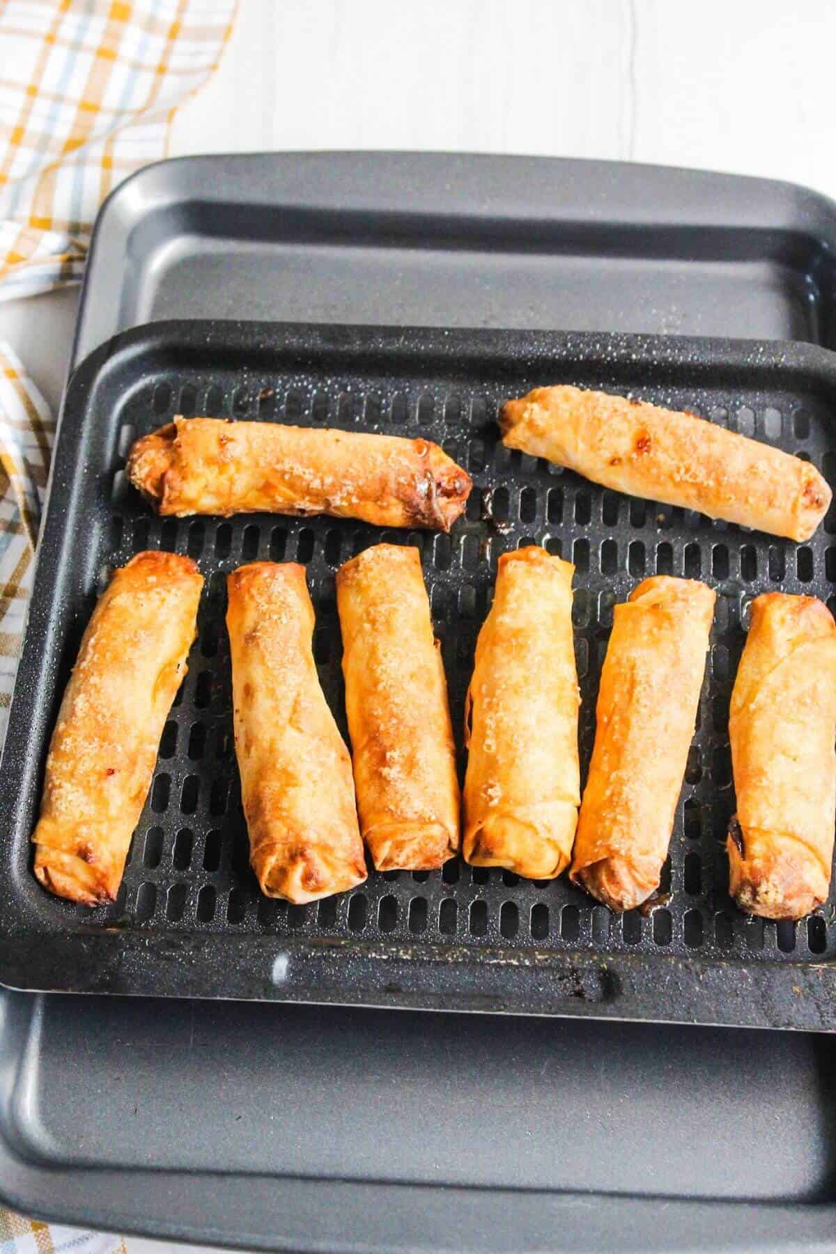 Fried banana turon lumpia rolls on a baking sheet.