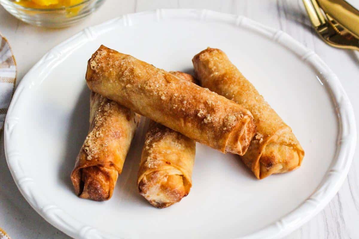 Banana turon Filipino lumpia on a white plate with a fork.
