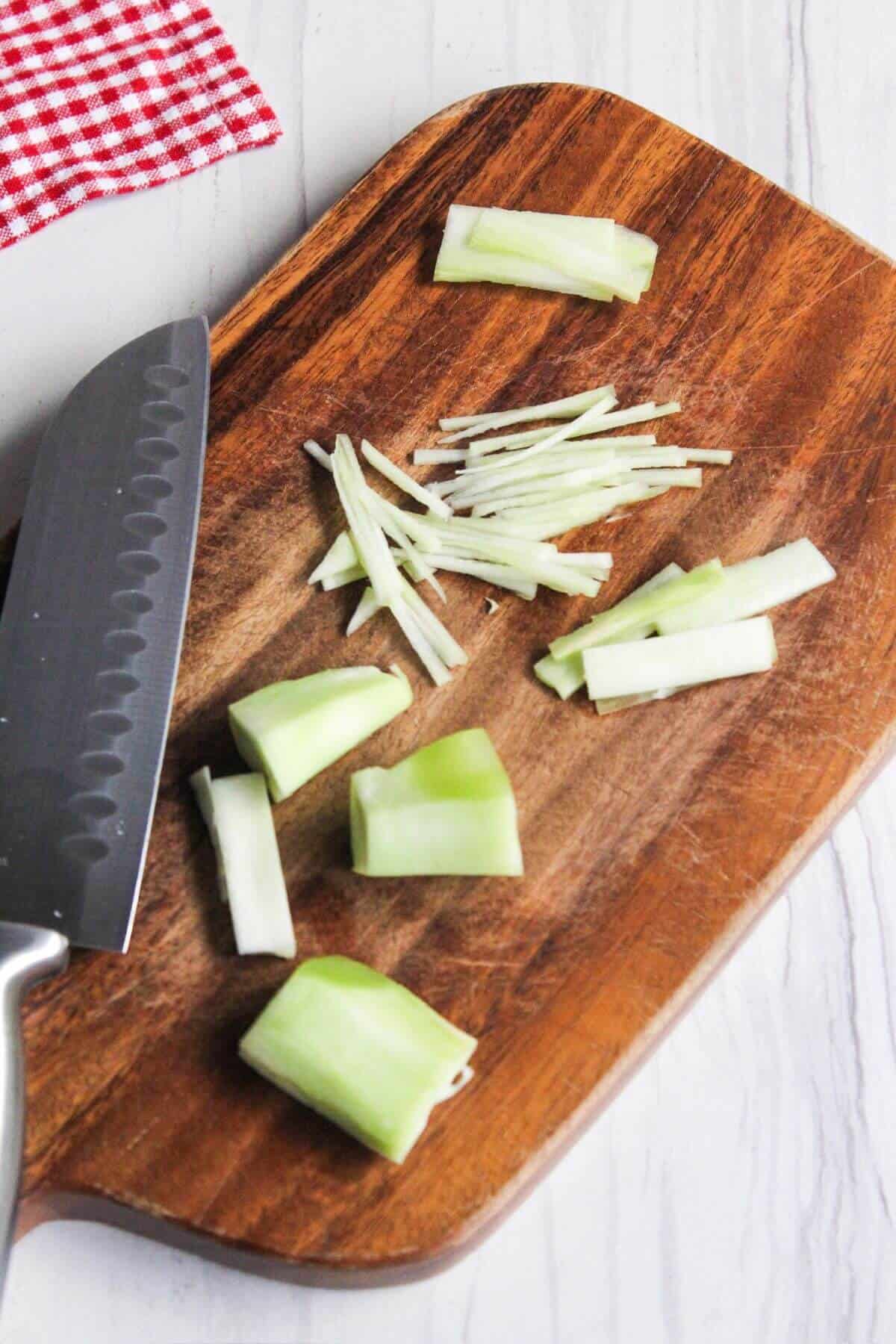 Sliced broccoli stems on a cutting board.