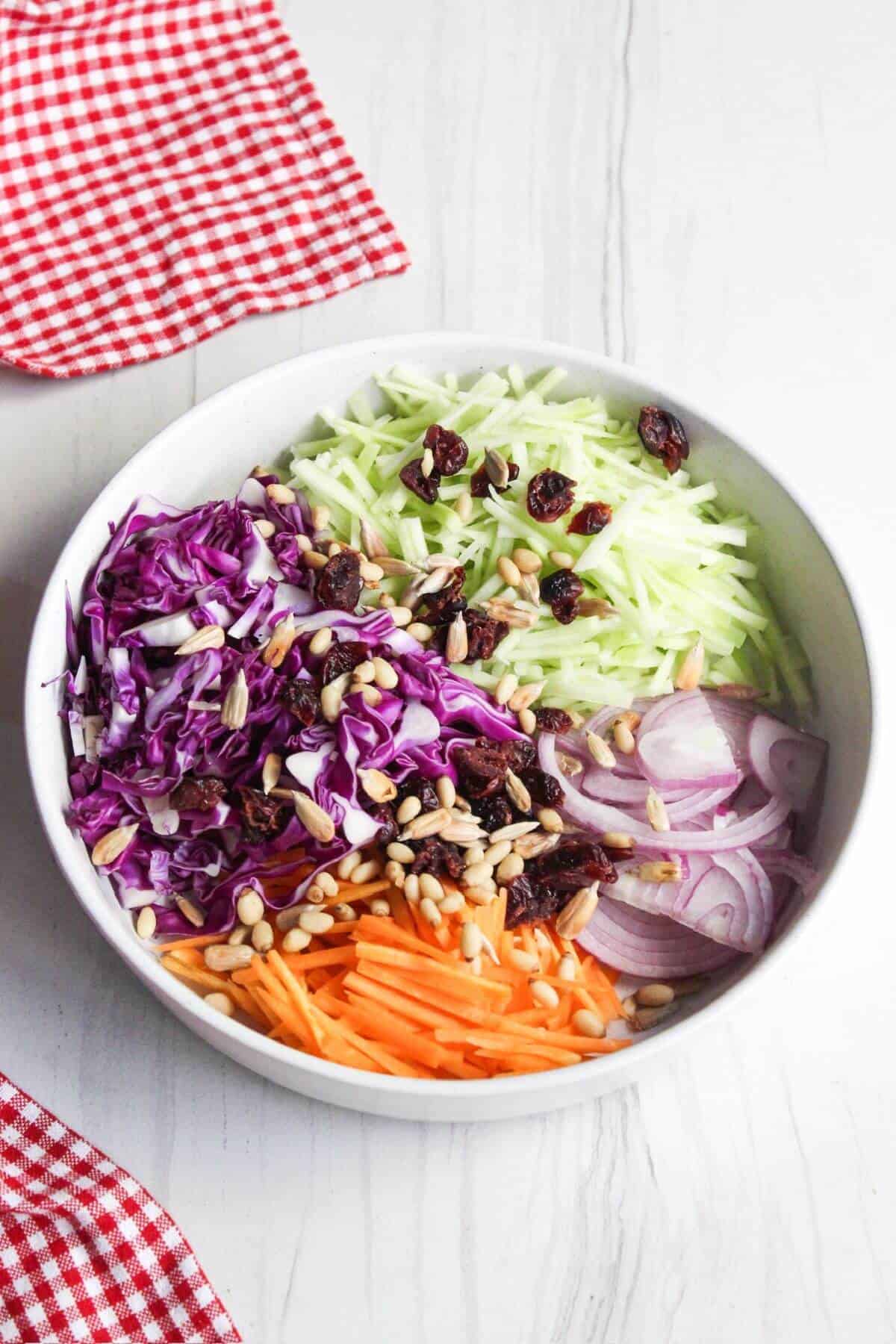 A bowl filled with broccoli slaw ingredients.