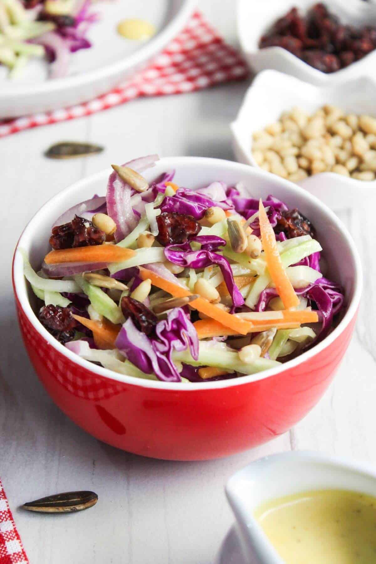 Broccoli slaw salad in small red bowl.