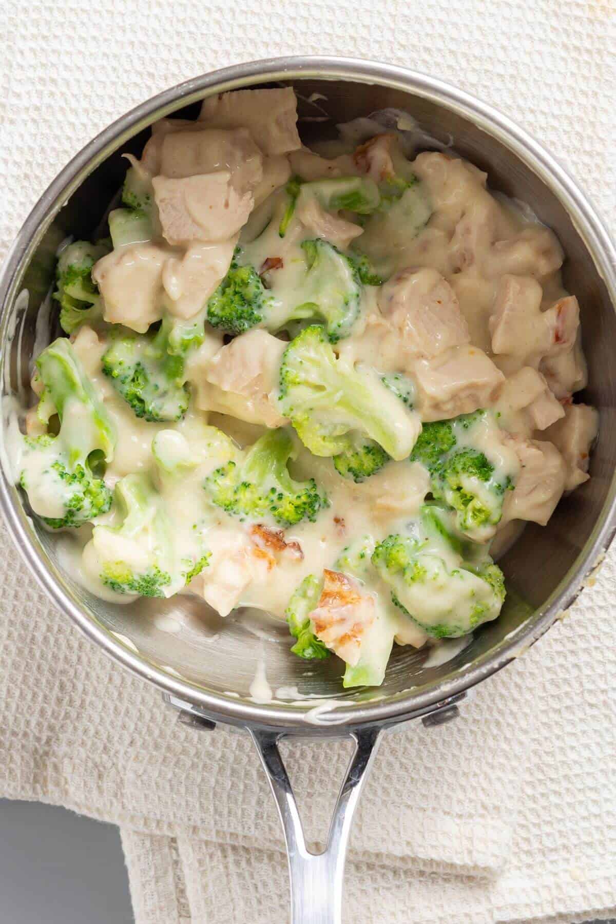 Chicken and broccoli mixed into the sauce in skillet.