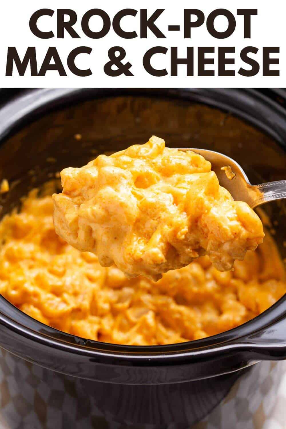 Crock pot mac and cheese with a spoon.
