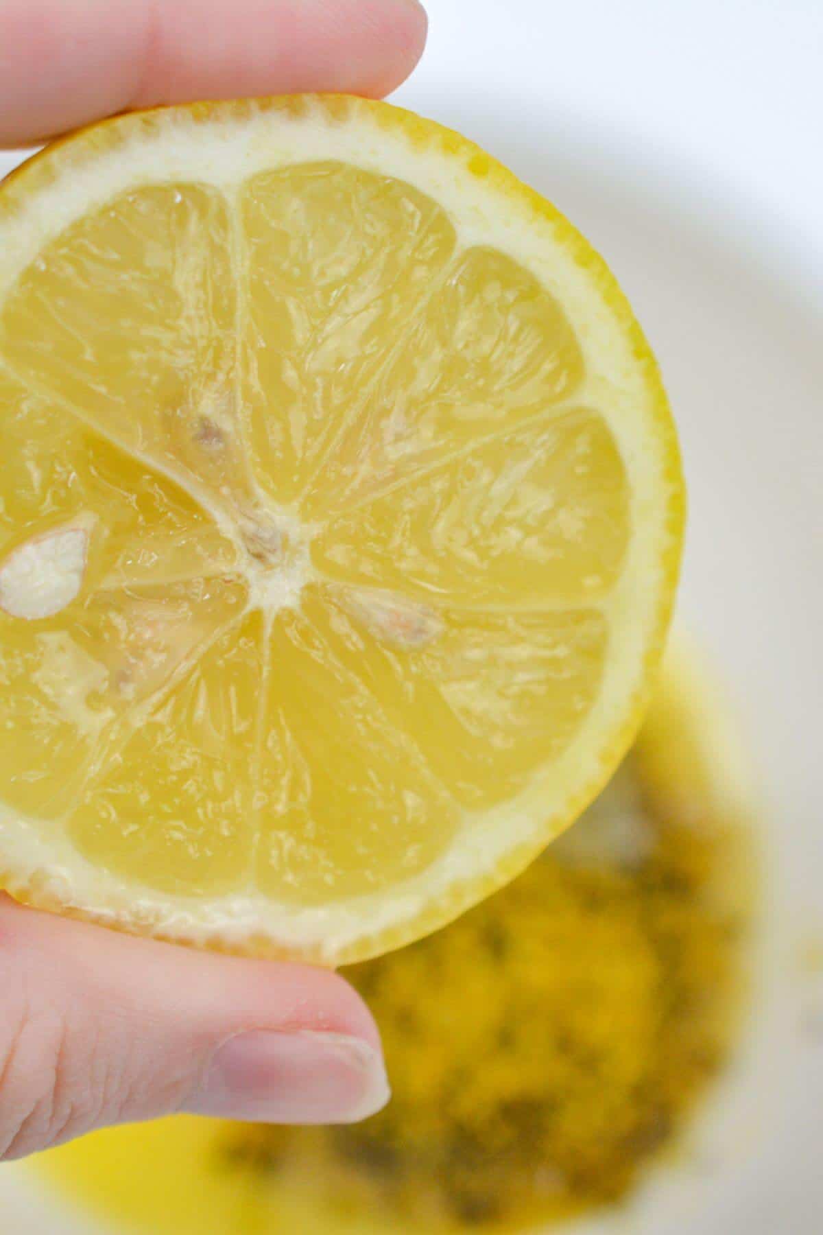 Adding squeeze of lemon juice melted butter in bowl.