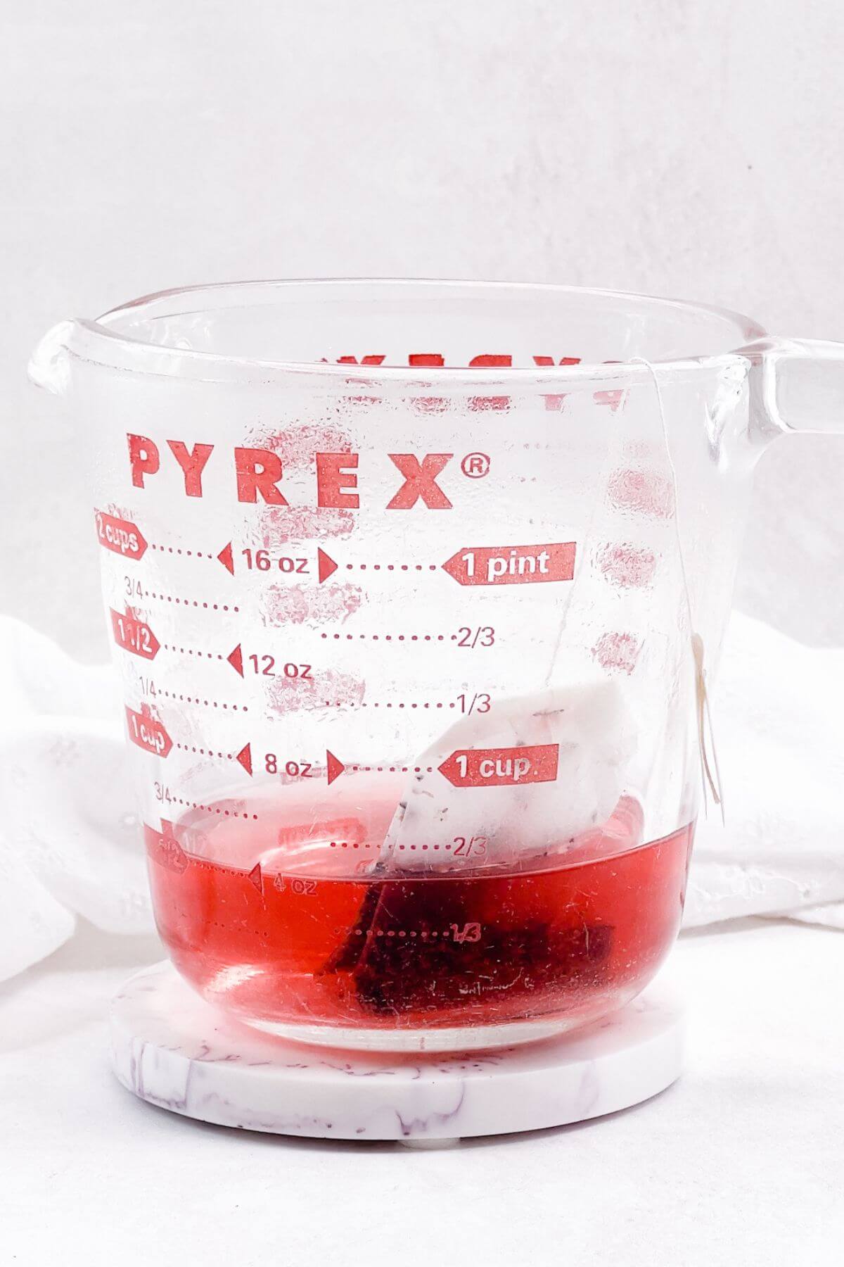 Brewing Tazo Passion Herbal Tea bag in Pyrex cup.