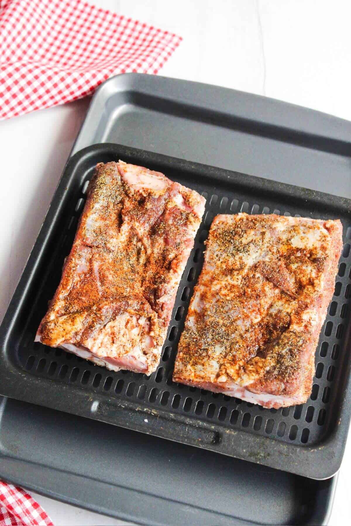 Two pieces of pork ribs on a grill pan.
