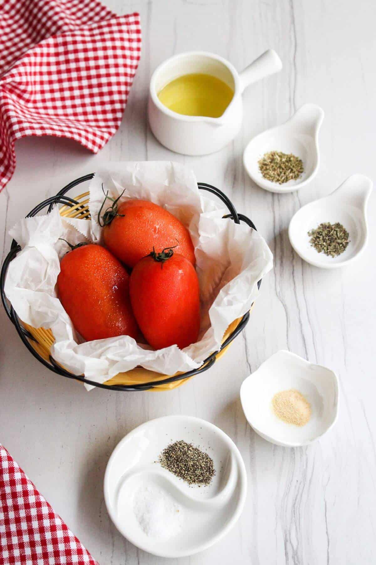 A bowl of tomatoes, herbs and spices on a table to make recipe.