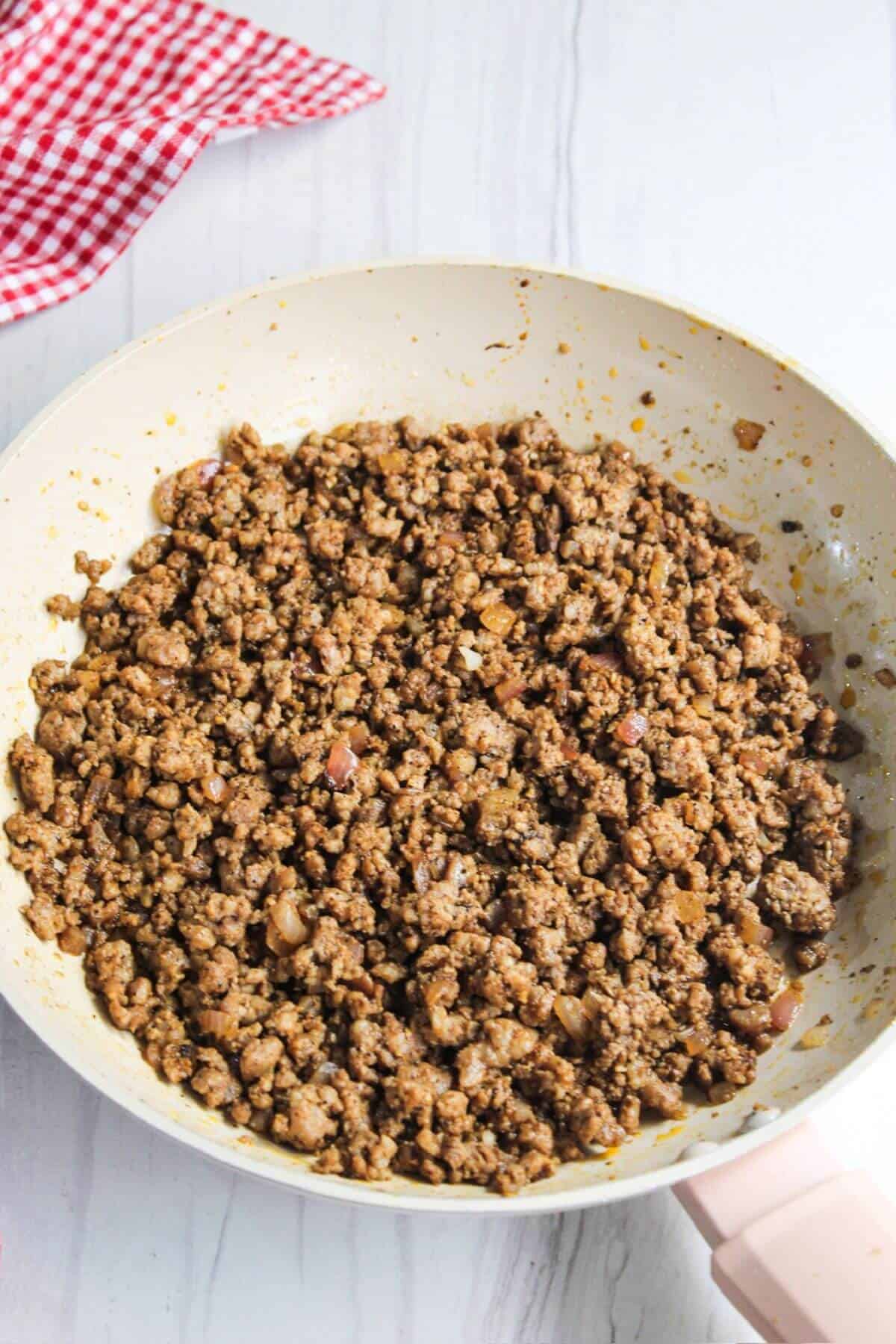 A frying pan filled with ground pork.