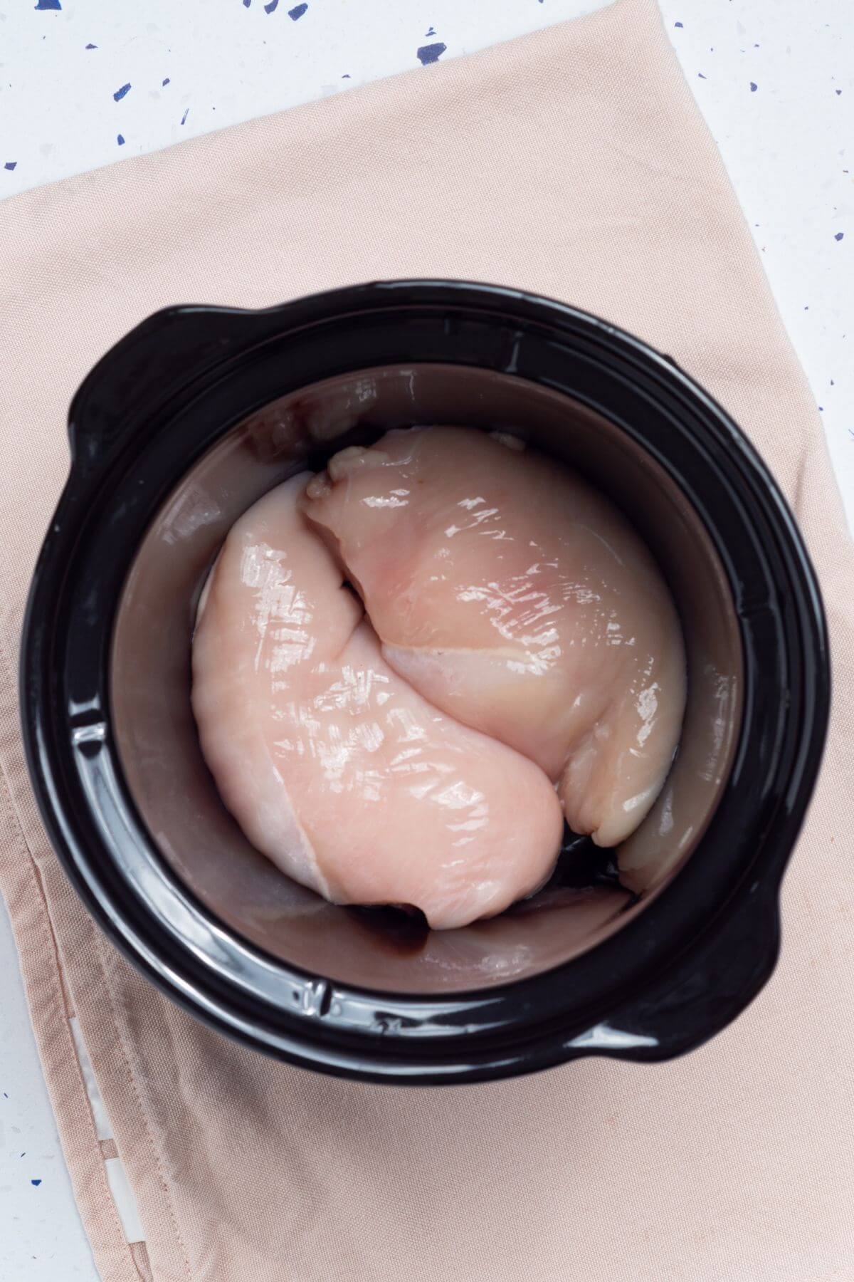 Chicken breasts in a slow cooker.